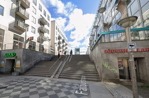 6 - Gå förbi nedgången till COOP och tag trappan ned mot      parken med de gröna träden